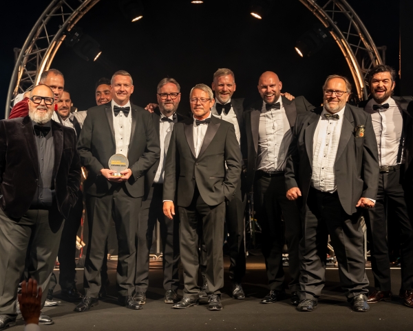 Men in suits on a stage.